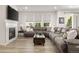 Cozy living room with a fireplace, plush sectional sofa, and lots of natural light from the large windows at 4089 Forever Cir, Castle Rock, CO 80109
