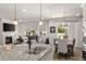 Open-concept floor plan flows from kitchen to living room with fireplace and dining room with pendant lighting at 4089 Forever Cir, Castle Rock, CO 80109
