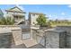 Outdoor kitchen with stone accents includes two grills, outdoor dining and views of nearby homes at 4089 Forever Cir, Castle Rock, CO 80109
