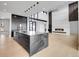 Modern kitchen with black marble island, stainless steel appliances and large living space at 8132 Galileo Way, Littleton, CO 80125