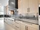 Modern kitchen with stone countertops and backsplash, with a gas range and stainless hood at 8132 Galileo Way, Littleton, CO 80125
