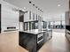 Bright and airy living room with fireplace and modern black kitchen with marble island at 8132 Galileo Way, Littleton, CO 80125