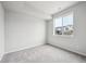 Bright bedroom with plush gray carpet, white walls, base trim, and a large window at 1352 Orchard St, Brighton, CO 80601