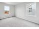 Bright, carpeted bedroom with natural light streaming through two windows at 1352 Orchard St, Brighton, CO 80601