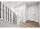 Bright foyer featuring hardwood floors, white walls, staircase with black iron railings, and a front door at 1352 Orchard St, Brighton, CO 80601