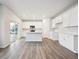 Open concept kitchen with white cabinets, stainless steel appliances, island, and laminate floors at 1352 Orchard St, Brighton, CO 80601