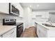 Close up of a modern kitchen with white cabinets, stainless steel appliances, and a kitchen island at 1352 Orchard St, Brighton, CO 80601