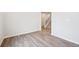 Spacious room with laminate flooring, white walls, base trim and access to the second floor staircase at 1352 Orchard St, Brighton, CO 80601