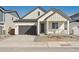 Charming single-Gathering home with a covered porch, gray two-car garage, and modern architectural details at 200 Lark Sparrow Way, Bennett, CO 80102