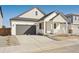 Charming single-Gathering home with a covered porch, gray two-car garage, and modern architectural details at 200 Lark Sparrow Way, Bennett, CO 80102