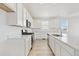 Modern kitchen featuring all-white cabinetry, stainless steel appliances, and a center island with a sink at 200 Lark Sparrow Way, Bennett, CO 80102