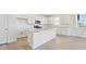 Bright, modern kitchen with a spacious island, clean white cabinets, and stainless steel appliances, perfect for cooking at 200 Lark Sparrow Way, Bennett, CO 80102