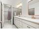 Modern bathroom with double sinks, geometric wallpaper, and a separate shower area at 14097 Double Dutch Cir, Parker, CO 80134