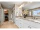 Bright bathroom featuring a double vanity, large mirror, and a view into a walk-in closet at 14097 Double Dutch Cir, Parker, CO 80134