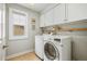 Functional laundry room with new front-loading washer and dryer and extra storage at 14097 Double Dutch Cir, Parker, CO 80134