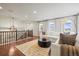 Second-floor living room with comfortable seating, hardwood floors, and a view from the large window at 14097 Double Dutch Cir, Parker, CO 80134