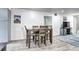 Dining room with seating for four open to the living room area with entertainment center at 420 Wright St # 101, Lakewood, CO 80228