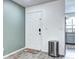 Neutral entryway featuring a white door, wood-look floors, and a sleek stainless steel trash receptacle at 420 Wright St # 101, Lakewood, CO 80228