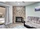 A stacked stone fireplace is the focal point of this room with a comfy sofa nearby and sliding door at 420 Wright St # 101, Lakewood, CO 80228
