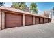 Row of garages with brown doors and neutral trim, offering convenient parking at 420 Wright St # 101, Lakewood, CO 80228