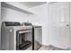 Modern laundry area with a front-loading washer and dryer, plus storage shelves at 420 Wright St # 101, Lakewood, CO 80228