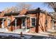 Brick home featuring a charming front porch and well-maintained exterior, nestled in a vibrant neighborhood at 1000 N Ogden St, Denver, CO 80218