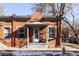 Quaint brick home with charming front porch, symmetrical windows, and a well-maintained exterior at 1000 N Ogden St, Denver, CO 80218