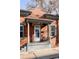 Charming red brick home with a covered front porch featuring classic columns and a cozy seating area at 1000 N Ogden St, Denver, CO 80218
