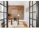 Charming home office with exposed brick wall, wood desk, and natural light streaming through glass doors at 1000 N Ogden St, Denver, CO 80218