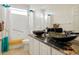 Bright bathroom boasts dual vessel sinks atop granite counters with modern fixtures and a shower-tub combination at 20292 E 47Th Ave, Denver, CO 80249
