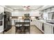 Modern kitchen with white cabinets, stainless steel appliances, an island with bar stools, and stylish backsplash at 20292 E 47Th Ave, Denver, CO 80249