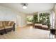 Open-concept living room showcasing light wood floors, comfortable seating, and an abundance of plants at 20292 E 47Th Ave, Denver, CO 80249