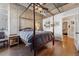 Modern bedroom with hardwood floors, exposed concrete walls and a four poster bed at 290 W 12Th Ave # 303, Denver, CO 80204