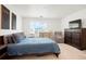 Comfortable bedroom with a dark wood bed frame, a dresser, and a cozy armchair at 21528 E 59Th Pl, Aurora, CO 80019