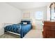 Bright bedroom with a metal bed frame, blue comforter, neutral carpet and a wooden dresser at 21528 E 59Th Pl, Aurora, CO 80019