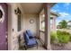 Cozy covered front porch with seating area and stone accents on support columns at 21528 E 59Th Pl, Aurora, CO 80019