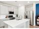 Contemporary kitchen featuring an island, stainless steel refrigerator, and ample cabinet space at 21528 E 59Th Pl, Aurora, CO 80019