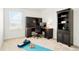Bright office space with dark wood desk and bookcase, complemented by a blue yoga mat and weights at 21528 E 59Th Pl, Aurora, CO 80019
