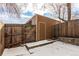 Backyard with a wooden storage shed and tall wooden fence, covered in snow at 4950 Homestead Pl # 23, Thornton, CO 80229