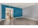 Open living space with hardwood floors, bold blue accent wall, and slider access to patio at 4950 Homestead Pl # 23, Thornton, CO 80229