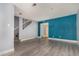 Bright living room with gray and blue accent walls, light wood floors, and modern stairwell at 4950 Homestead Pl # 23, Thornton, CO 80229