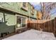 Back patio with a wooden fence and sliding glass door, covered in snow at 4950 Homestead Pl # 23, Thornton, CO 80229