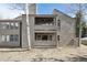Exterior view of a two-story condo featuring double balconies, a wood-paneled facade, and mature trees at 23561 Genesee Village Road # C, Golden, CO 80401