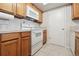Efficient kitchen with white oven and microwave, warm wood cabinets, tile counters and flooring at 23561 Genesee Village Road # C, Golden, CO 80401