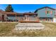 The backyard features a wood deck and stone patio covered by a pergola with seating, plus lawn at 19228 E Arizona Pl, Aurora, CO 80017