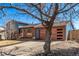 Charming two-story home with a brick and blue wood exterior, a wood garage door and a spacious driveway at 19228 E Arizona Pl, Aurora, CO 80017