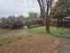Backyard view shows mature trees, partial perimeter fence, and stone landscaping, offering a peaceful outdoor setting at 880 Orion Dr, Lafayette, CO 80026