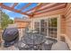 View of back deck, with table, chairs, grill and sliding door leading to interior space at 9784 S Iris Ct, Littleton, CO 80127
