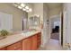 Bathroom featuring wood cabinets, a large mirror, and tile flooring at 9784 S Iris Ct, Littleton, CO 80127