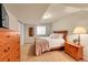 Bedroom with light colored carpet and walls, and a wood dresser and bed frame at 9784 S Iris Ct, Littleton, CO 80127